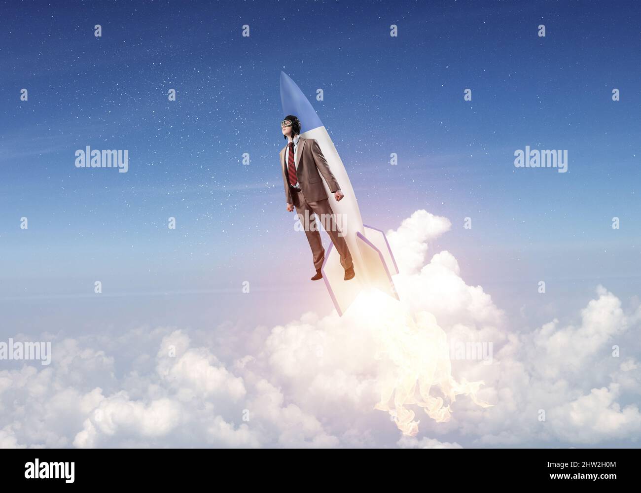 Business person in aviator hat flying on rocket Stock Photo