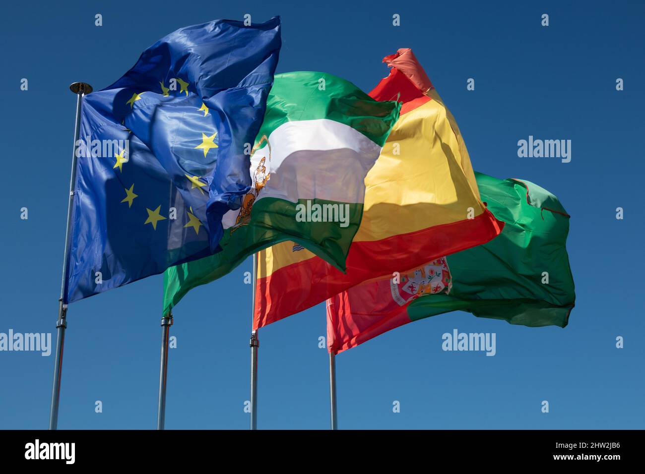 The flags of the EU, Spain, Andalusia and the city of Granada fly from the roof of the Alhambra in Granada, Spain. Stock Photo