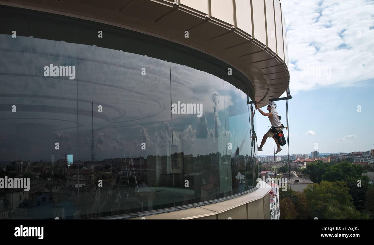 Industrial mountaineering worker professional window washer hanging on ...