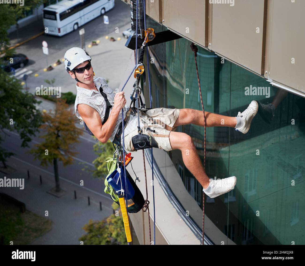 Industrial mountaineering man cleaning service worker hanging on