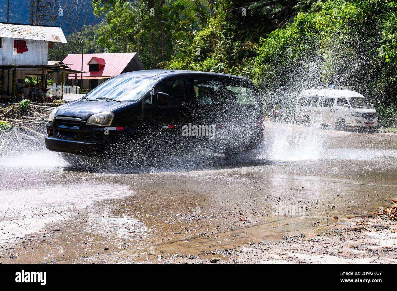 Puddle Van A mid-size van in puddles, mud and splashes. The Peruvian jungle in the ...