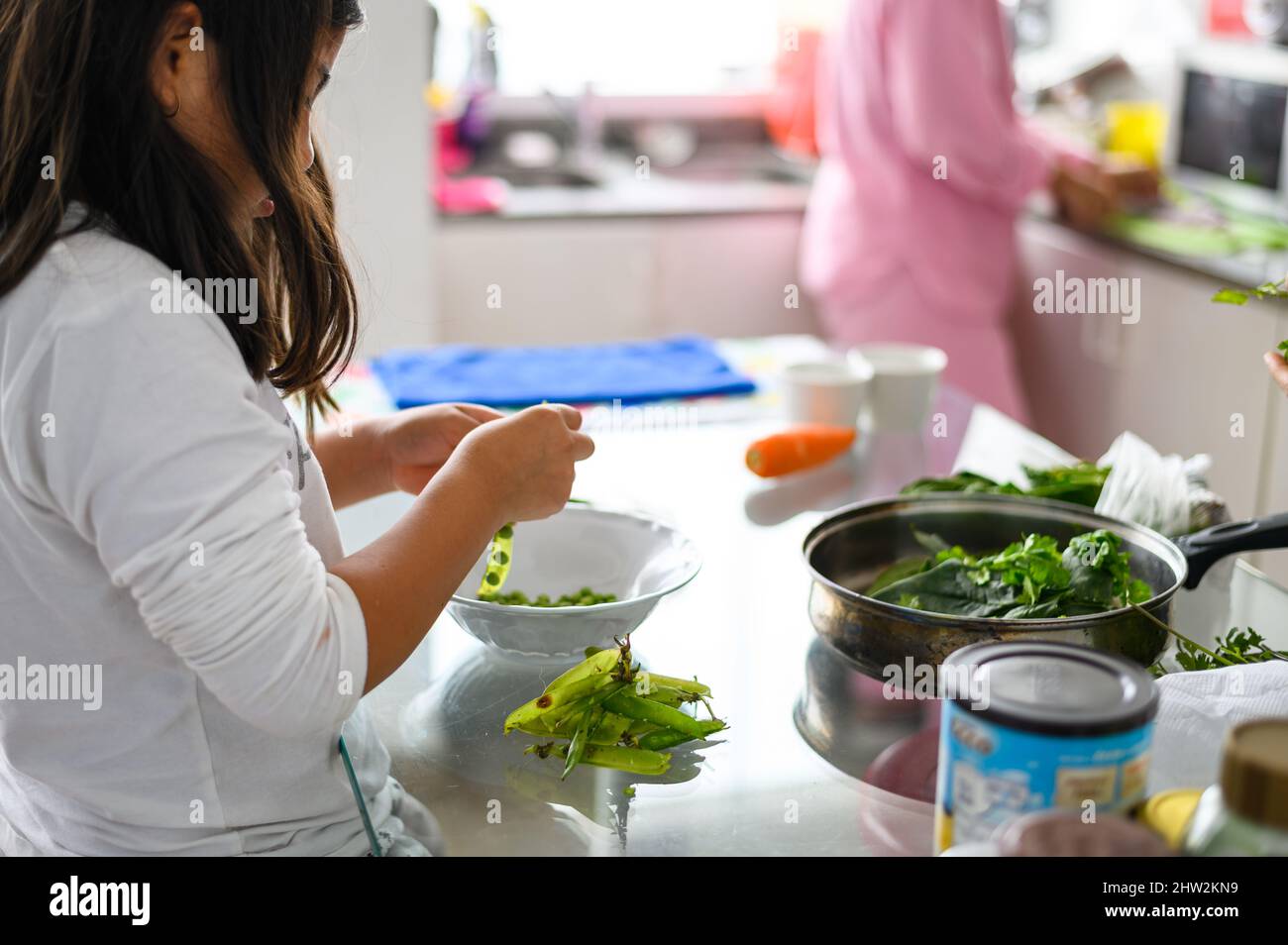 cleaning and help in the home. child development. little girl helping in the kitchen. little girl prepare healthy food at home Stock Photo