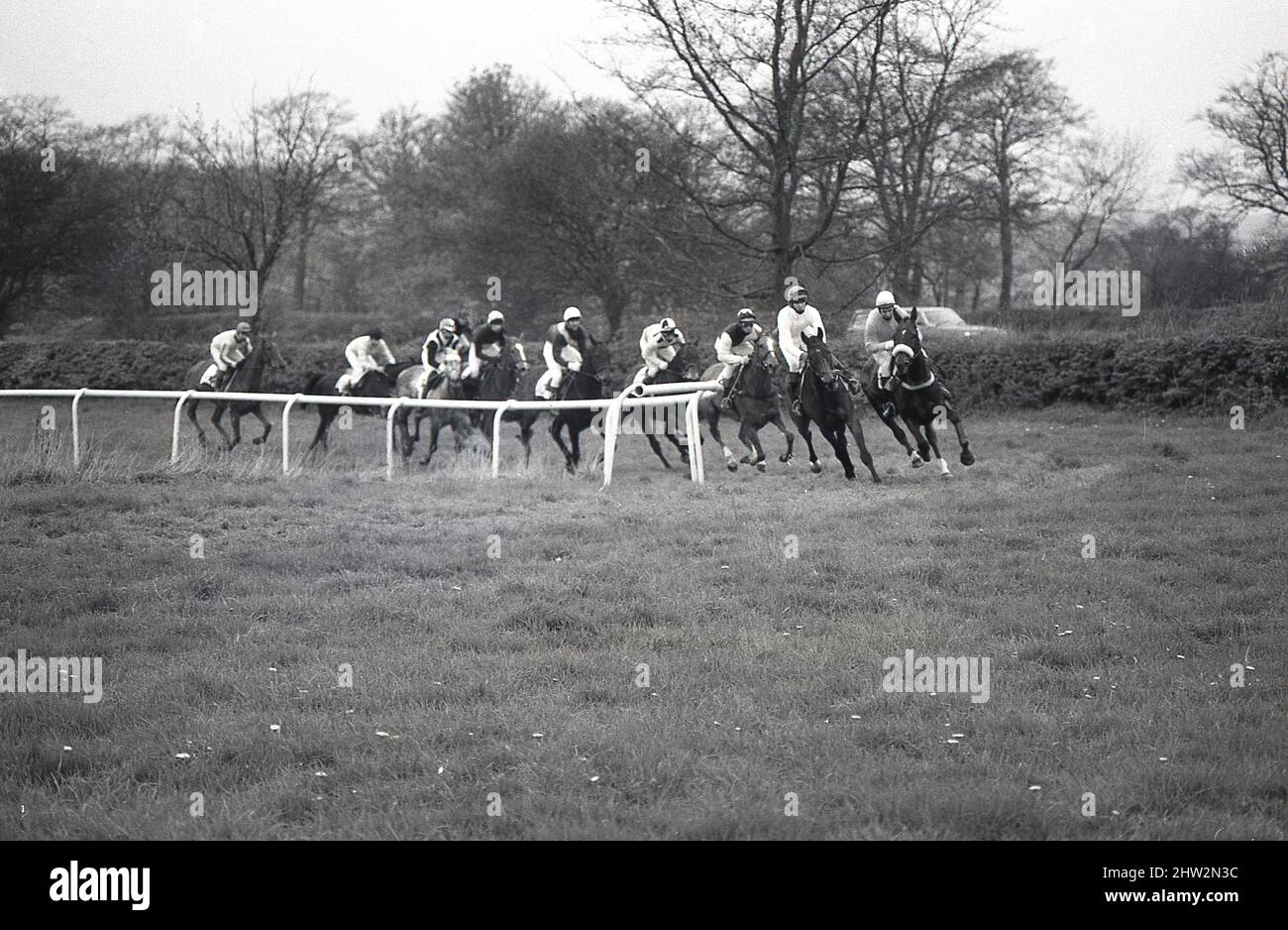 1987, historical, Middleton Point-to-Point, jockeys on horses coming around a turn at the course at Whitwell-on-the-Hill, York, England, UK. A Point-to-Point is a form of amateur horse racing over fences, which orginated in England in the 19th century as a way of keeping horses ridden at fox hunts fit. They were first called hunt races. Stock Photo
