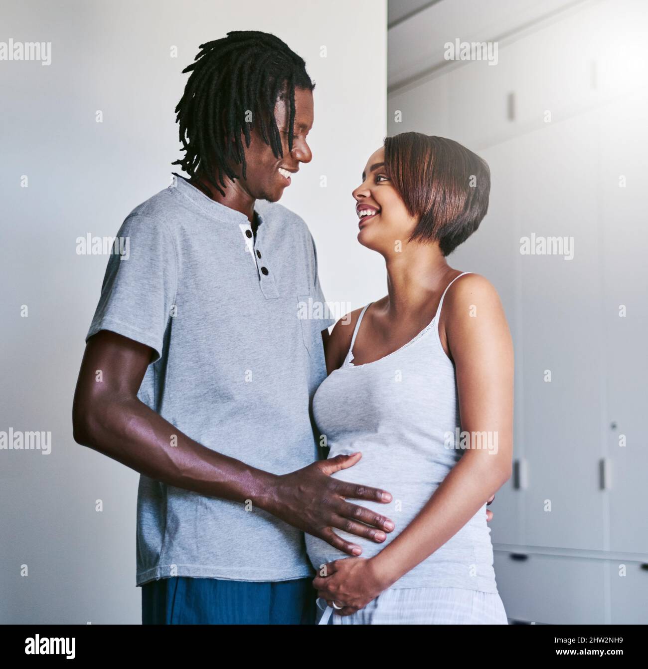 Smiling man touching wifes belly hi-res stock photography and images
