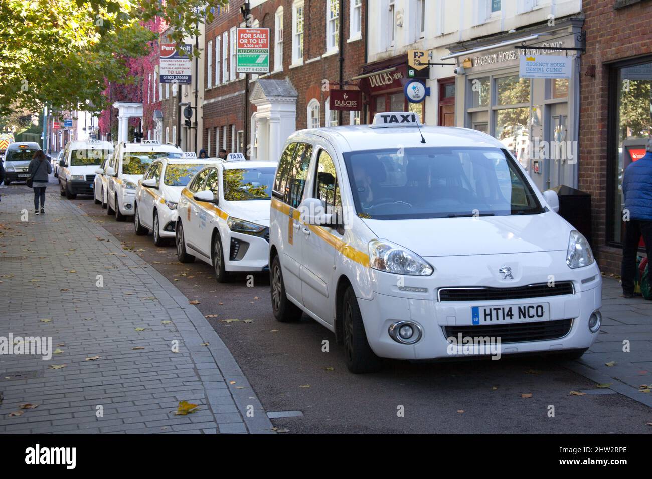 Taxis in a taxi rank in St Albans, Hertfordshire in the UK Stock Photo