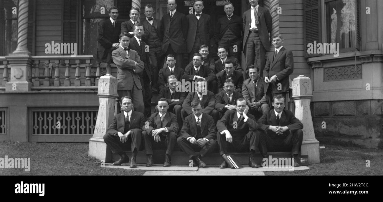 1930s, historical, male teachers gathered together for a group photo on the wide steps of their college or grammar school building, a mansion house, Ohio, USA. Formal dress of the day, suits, stiff collars - some with bowties - and ankle high lace-up boots. Stock Photo