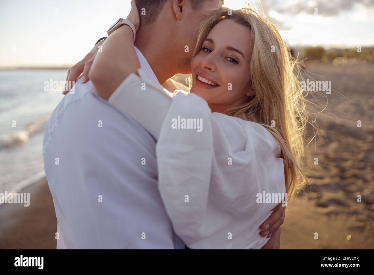 Close-up of beautiful woman hugging man on the beach Stock Photo - Alamy