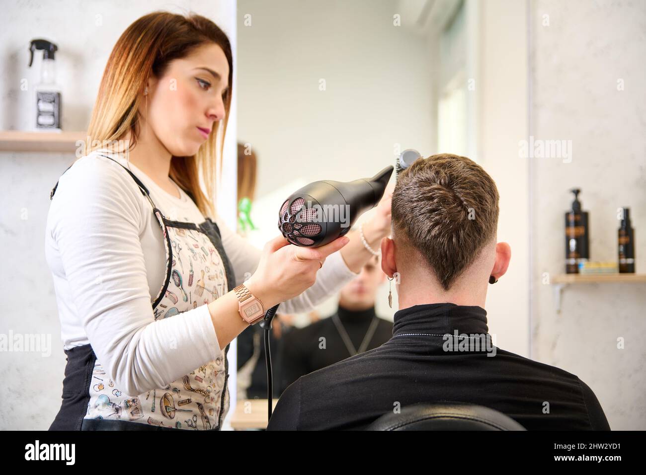 Hairdresser cutting hair and styling a client in the barbershop Stock Photo