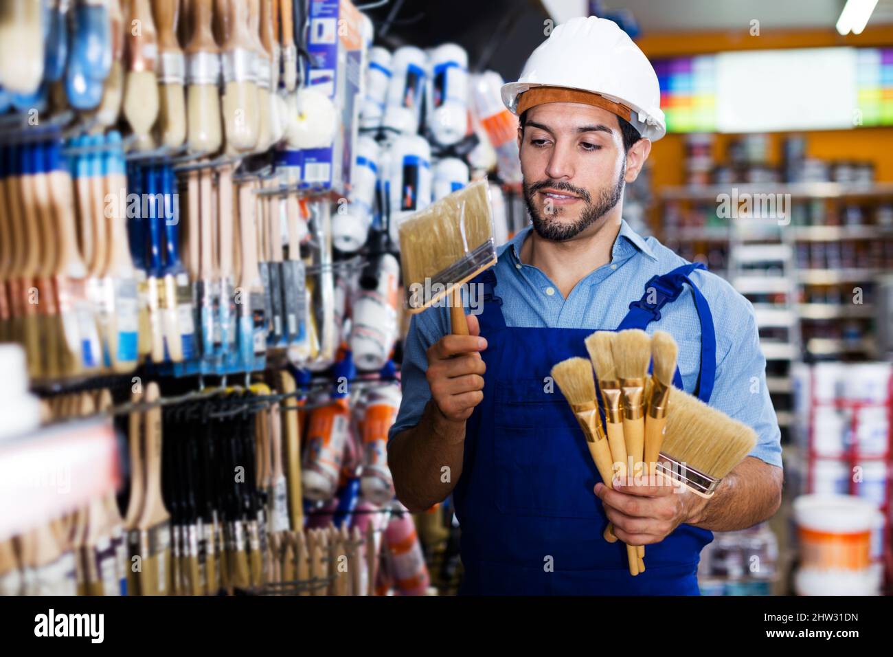Workman selecting brushes in store Stock Photo Alamy