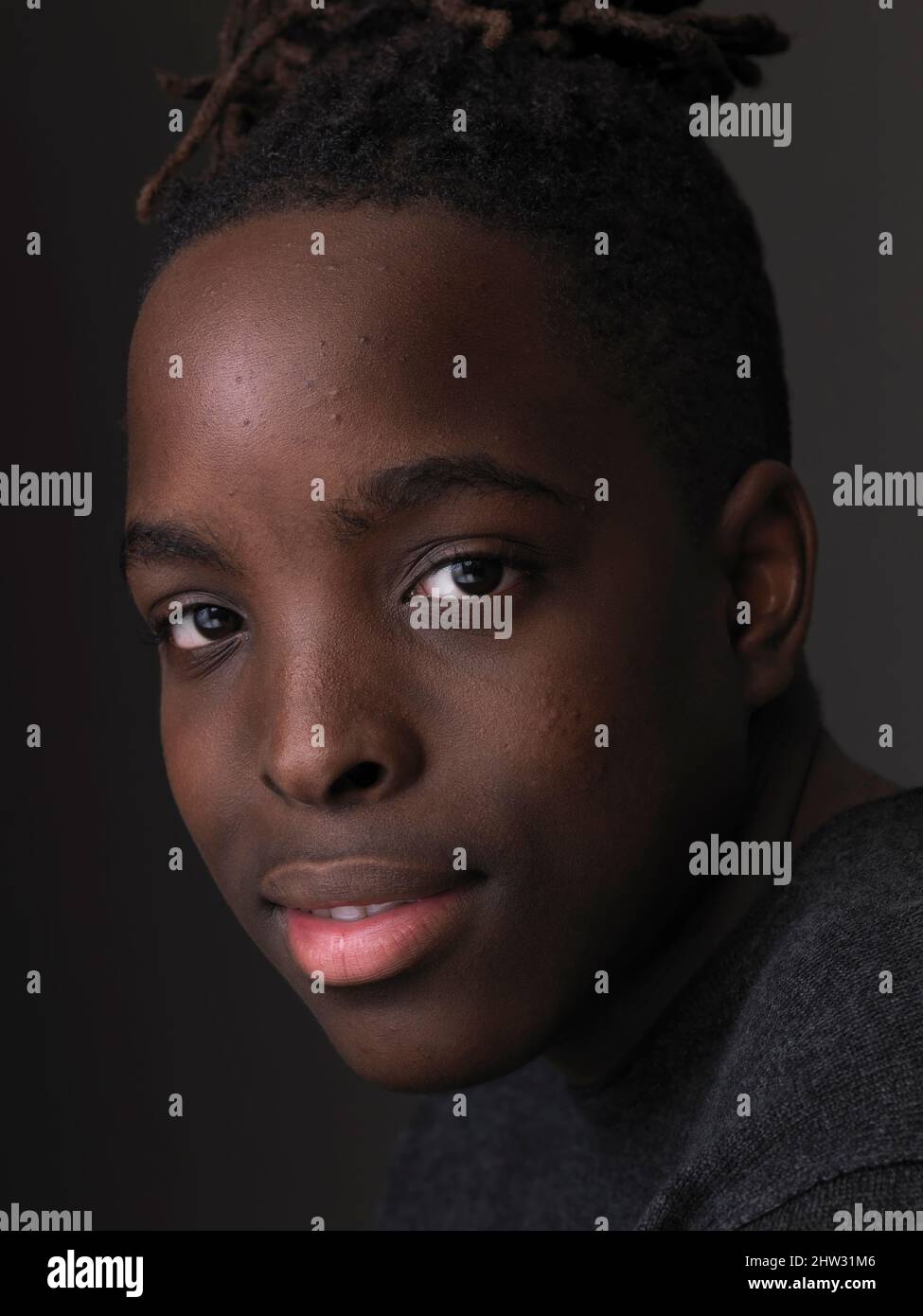 studio portrait of the beautiful face of a young man looking at camera ...