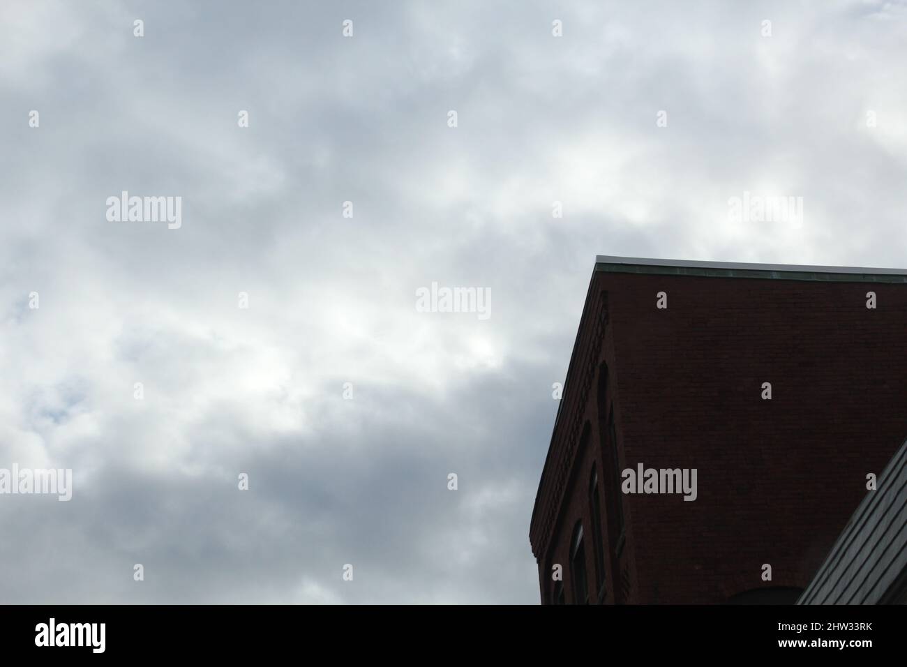 Low angle of a brick building with a cloudy sky background Stock Photo ...