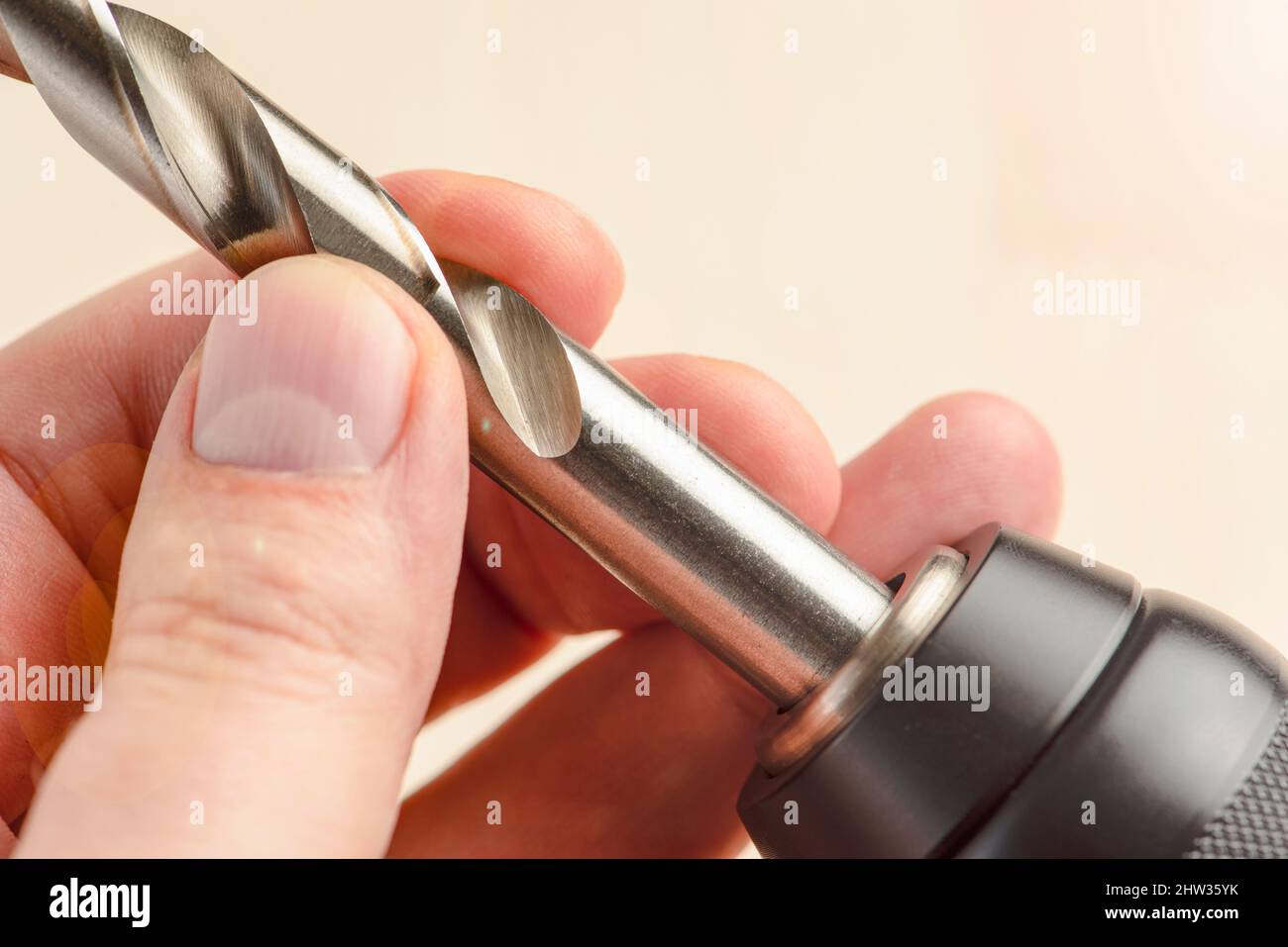 Installing a drill bit in a drill, hands take a drill and install it in