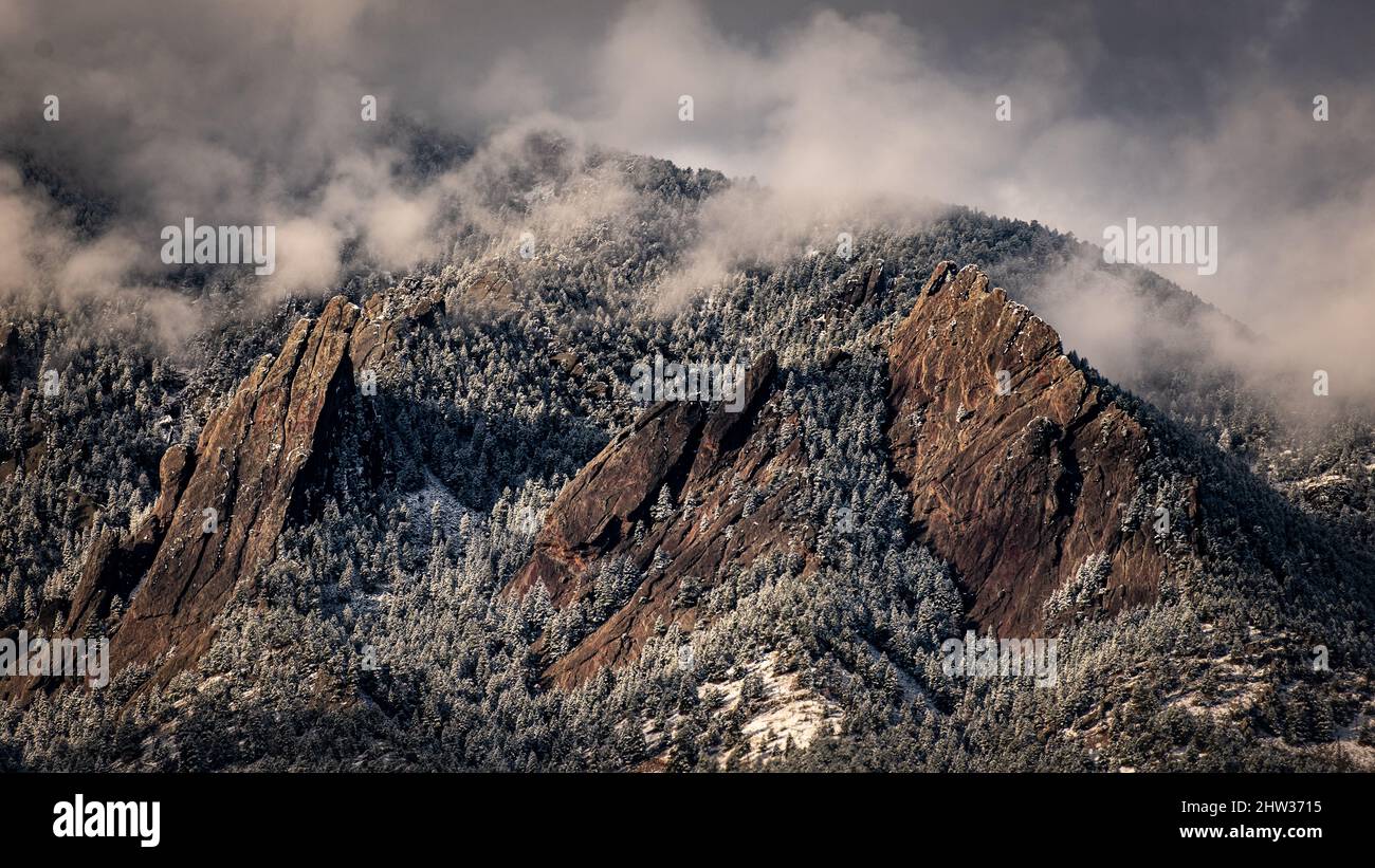 Snow and clouds cover the Flatirons in Boulder, Colorado Stock Photo