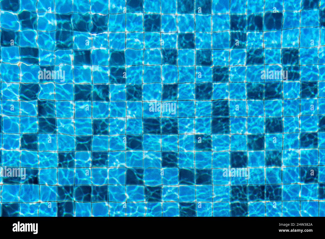 Swimming pool top down view into rippled blue water and tiled floor design, summer beach party background. Stock Photo