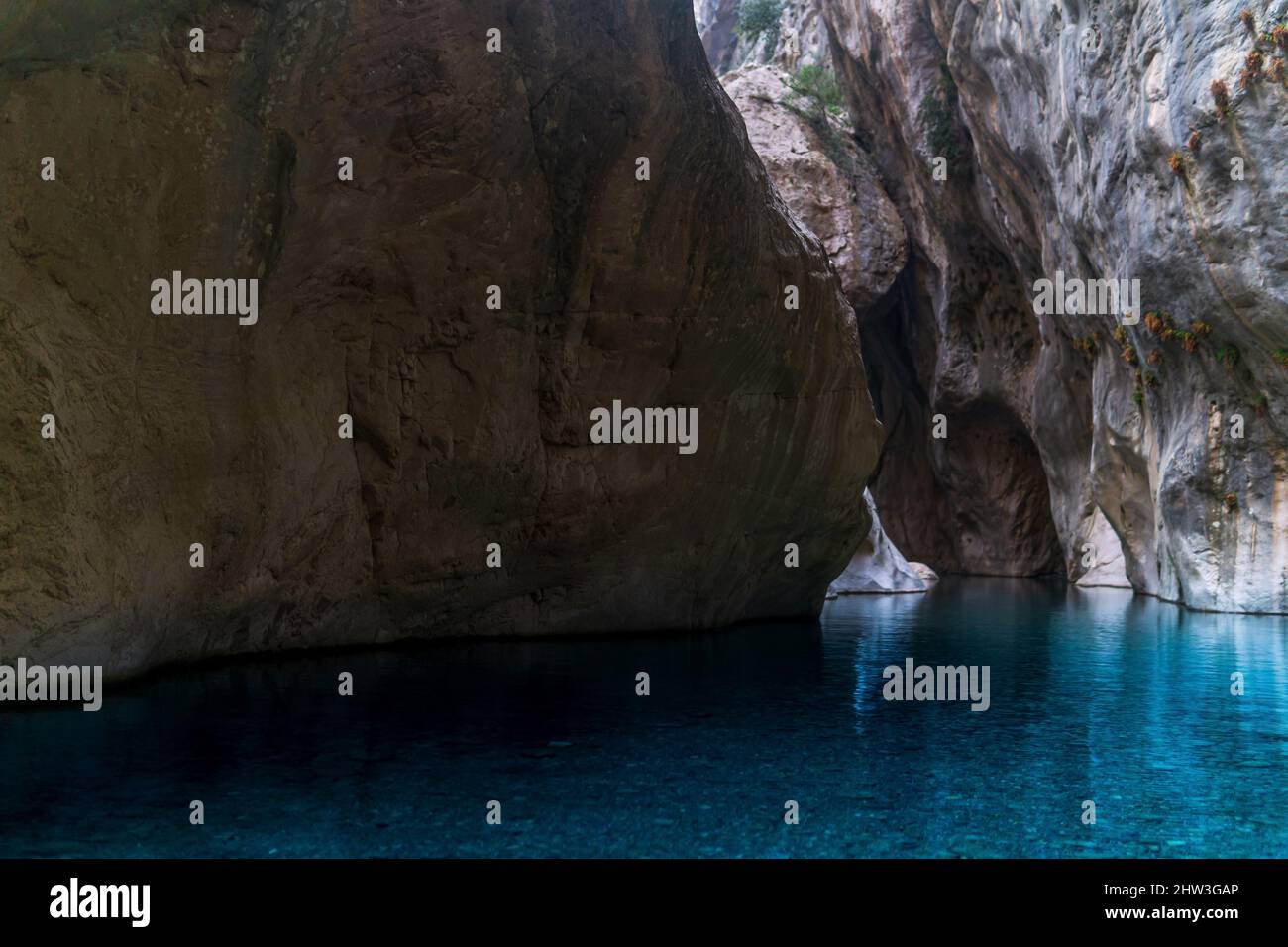 clear blue water in a deep canyon with sheer rock walls. Stock Photo