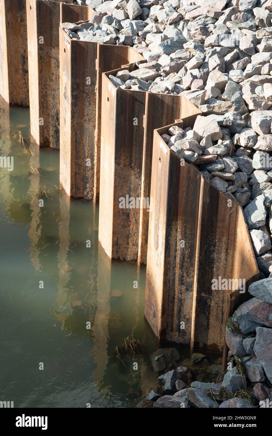 Sheet metal, piling, position, located in ground, supporting, river banks, interlocking edges, driven into ground, earth retention excavation support. Stock Photo