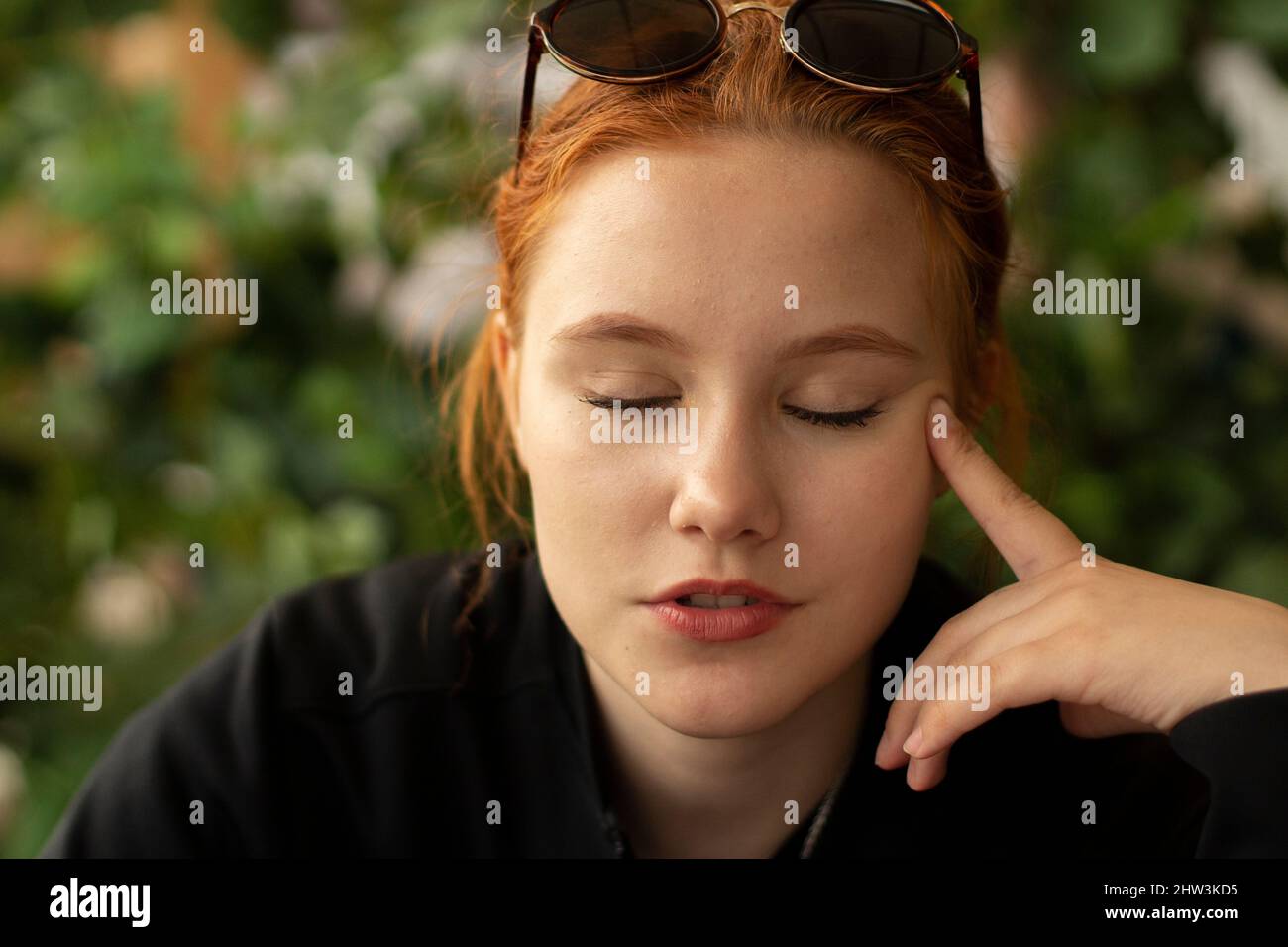 Portrait of a young girl. A girl of European appearance. The teenager looks into the camera with a tired look. Dreamy mood on the face. Stock Photo