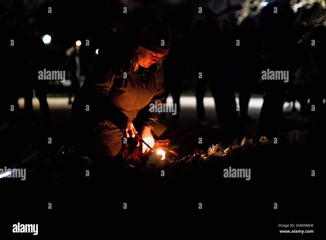 A person lights a candle at Clapham Common in south London, ahead of a march to mark the first anniversary of the murder of Sarah Everard. The 33 year old was raped and killed by serving Met officer Wayne Couzens as she walked home in south London on March 3 last year. Picture date: Thursday March 3, 2022. Stock Photo