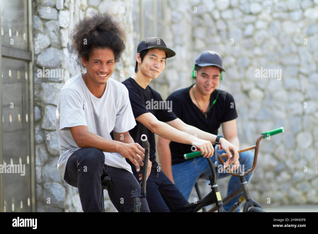 Just chilling between tricks. A group of young bmx riders relaxing together. Stock Photo