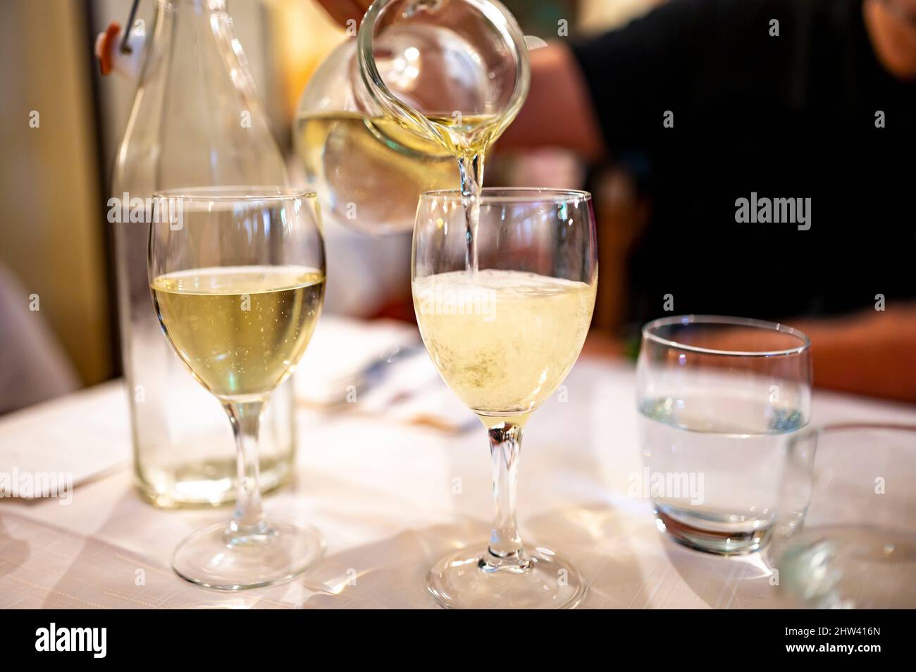 Italian white house wine served in pitcher with two glasses