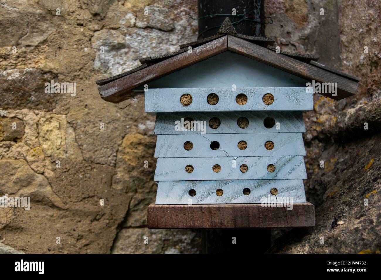 Small bug hotel known as a wildlife hotel or stack, house like construction made to help various insects to survive winter and free to leave in spring Stock Photo