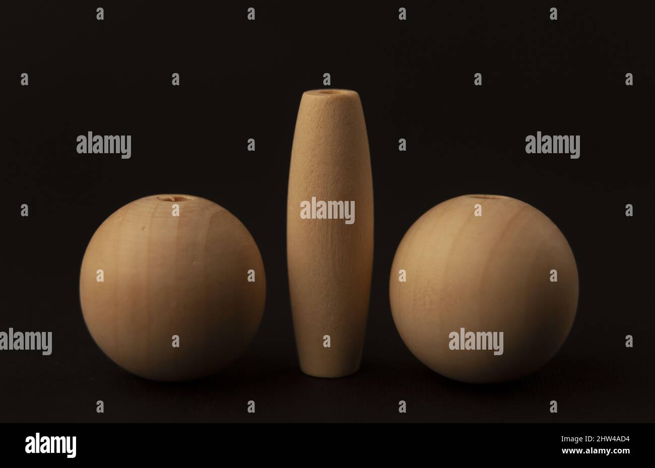 two wooden balls and cylinder on black background, big balls, close up Stock Photo