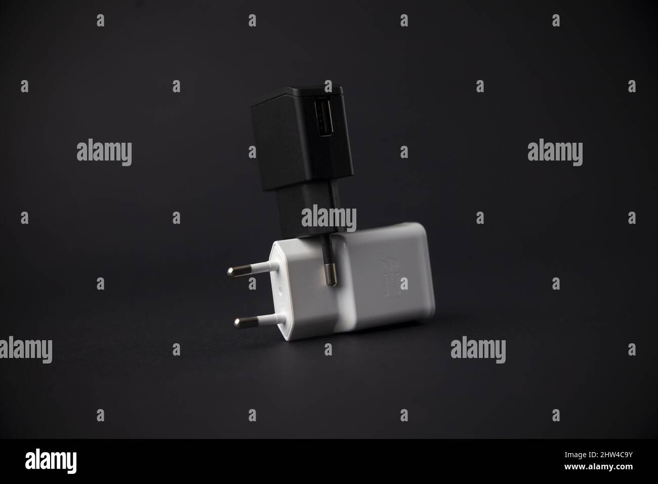 black and white mobile phone charger against each other, close up Stock Photo