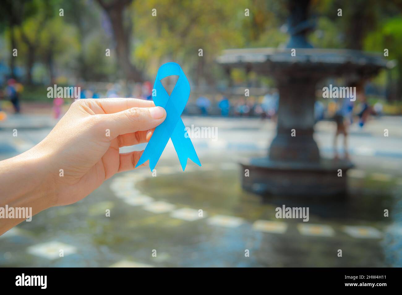 November Prostate Cancer Awareness month, woman holds up a blue ribbon with her hand to support those living with and sick. World Cancer Day concept Stock Photo