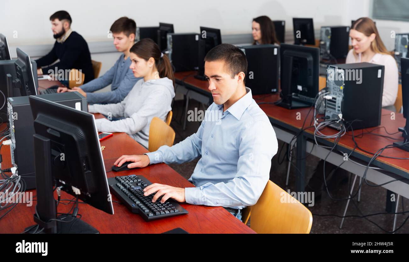 Group of people learning to use computers in classroom Stock Photo - Alamy
