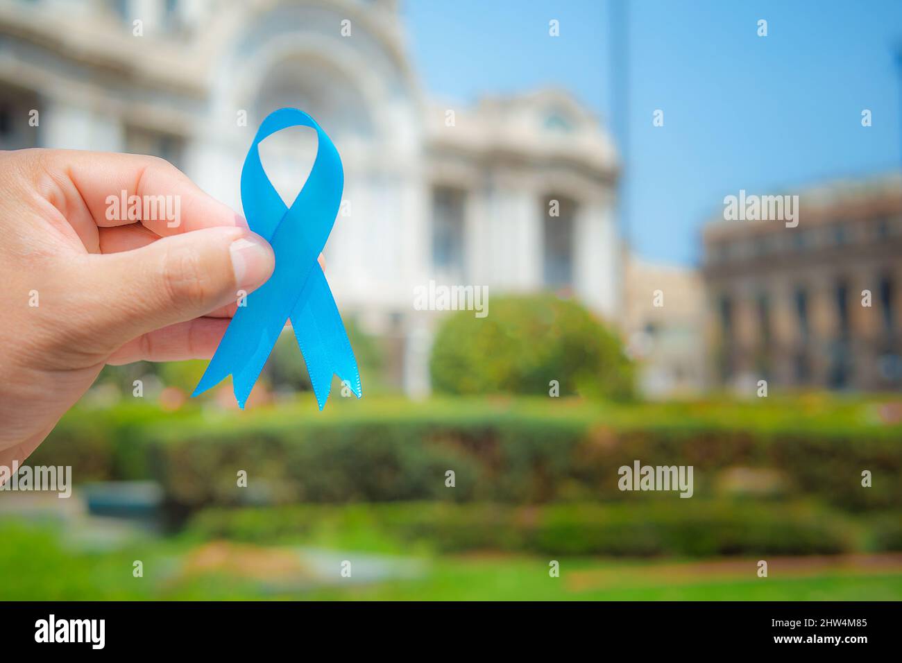 November Prostate Cancer Awareness month, woman holds up a blue ribbon with her hand to support those living with and sick. World Cancer Day concept Stock Photo