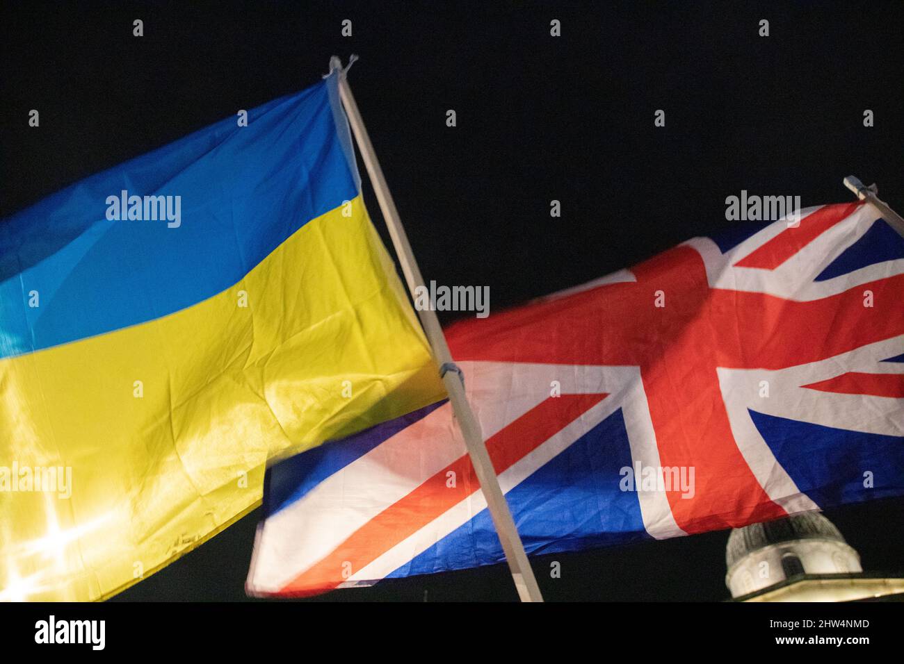 London, England. 3rd March 2022.  A British and an Ukrainian Flag together as Ukrainians and supporters of Ukraine have gathered on Trafalgar Square to protest against Russia's invasion of Ukraine. Stock Photo