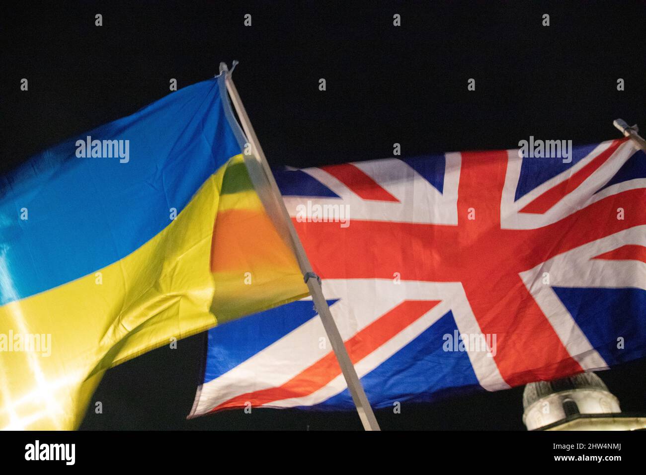 London, England. 3rd March 2022.  A British and an Ukrainian Flag together as Ukrainians and supporters of Ukraine have gathered on Trafalgar Square to protest against Russia's invasion of Ukraine. Stock Photo
