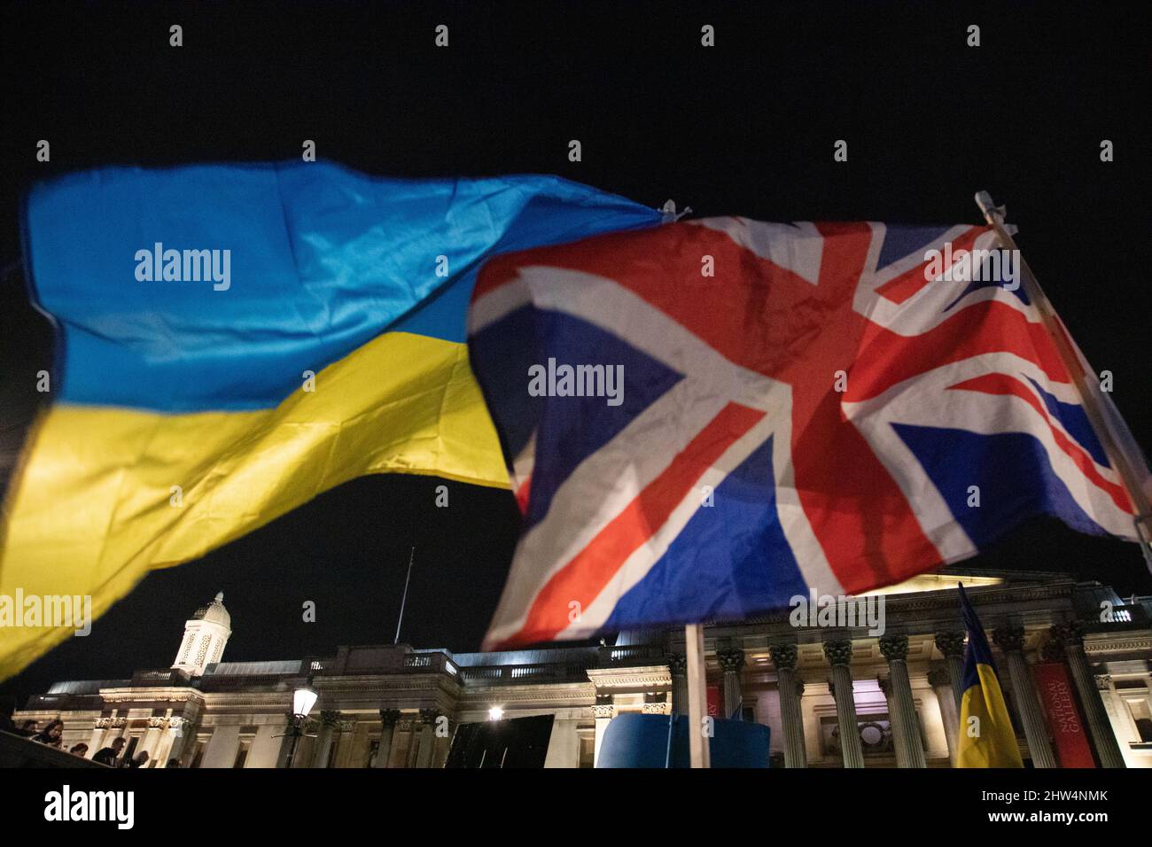 London, England. 3rd March 2022.  A British and an Ukrainian Flag together as Ukrainians and supporters of Ukraine have gathered on Trafalgar Square to protest against Russia's invasion of Ukraine. Stock Photo