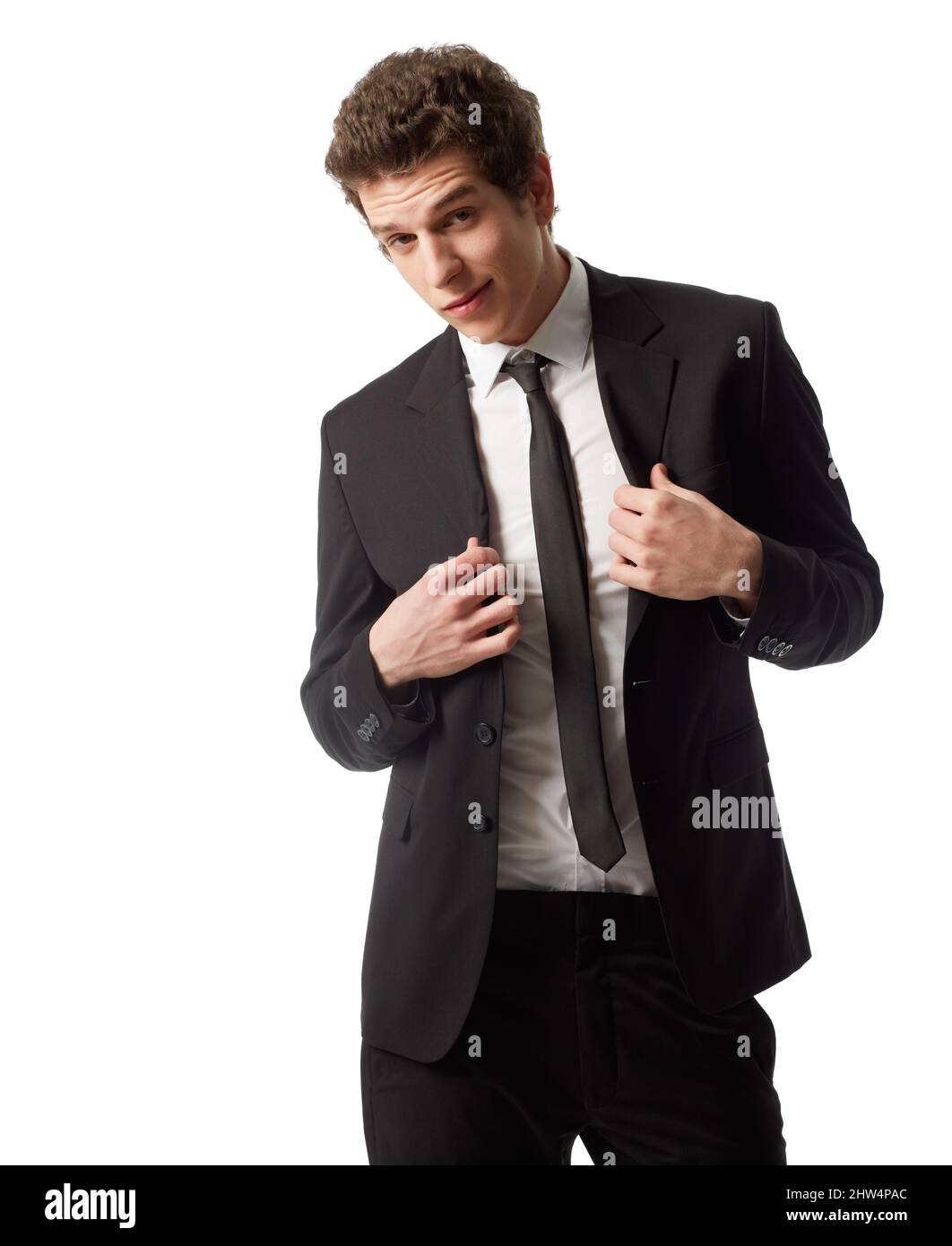 Suit up. A young man wearing a suit and tie standing in front of a white background. Stock Photo