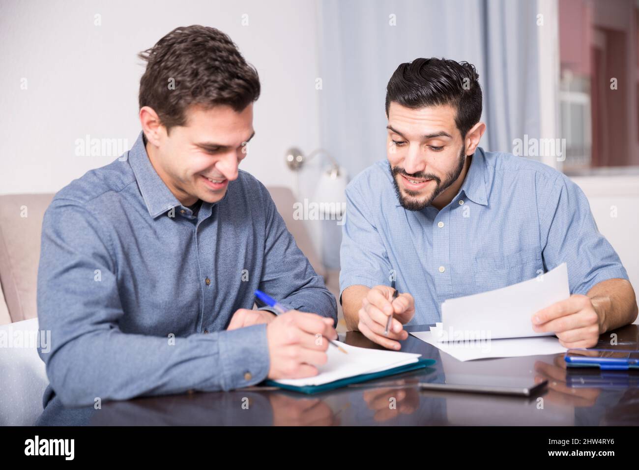 Readind Documents Two cheerful men reading documents at table Stock Photo - Alamy