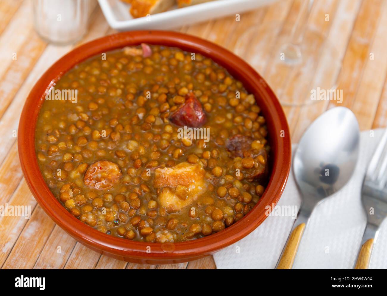 Stewed lentils with chorizo and vegetables in earthenware bowl Stock Photo  - Alamy