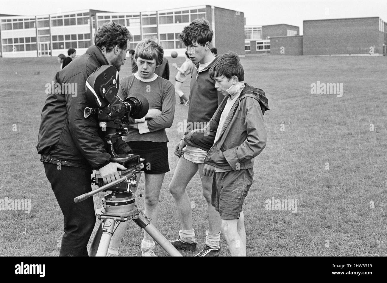 David Bradley (on the right), (aged 14) playing the part of Billy Casper, pictured with his Kestral, on the film set of the film Kes.   Here Billy Casper is talking to the film crew on the school playing film, during the famous football scene. Kes is a 1969 release drama film directed by Ken Loach and produced by Tony Garnett. The film is based on the 1968 novel A Kestrel for a Knave, written by the Barnsley-born author Barry Hines. The film is ranked seventh in the British Film Institute's Top Ten (British) Films and among the top ten in its list of the 50 films you should see by the age of 1 Stock Photo