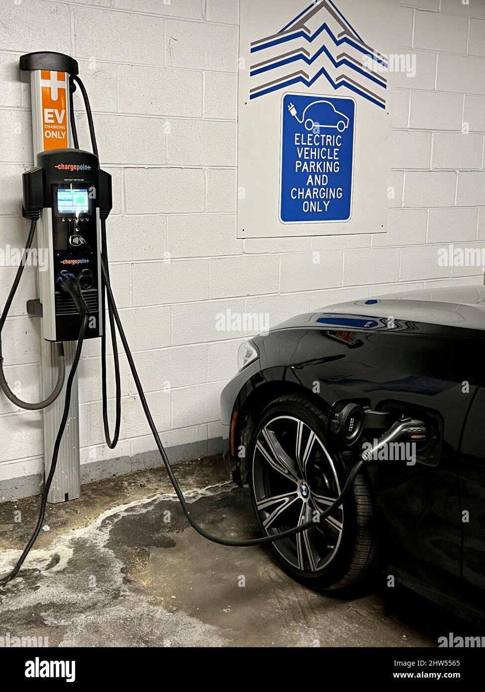 Electric vehicle charging station inside a parking garage, with a car