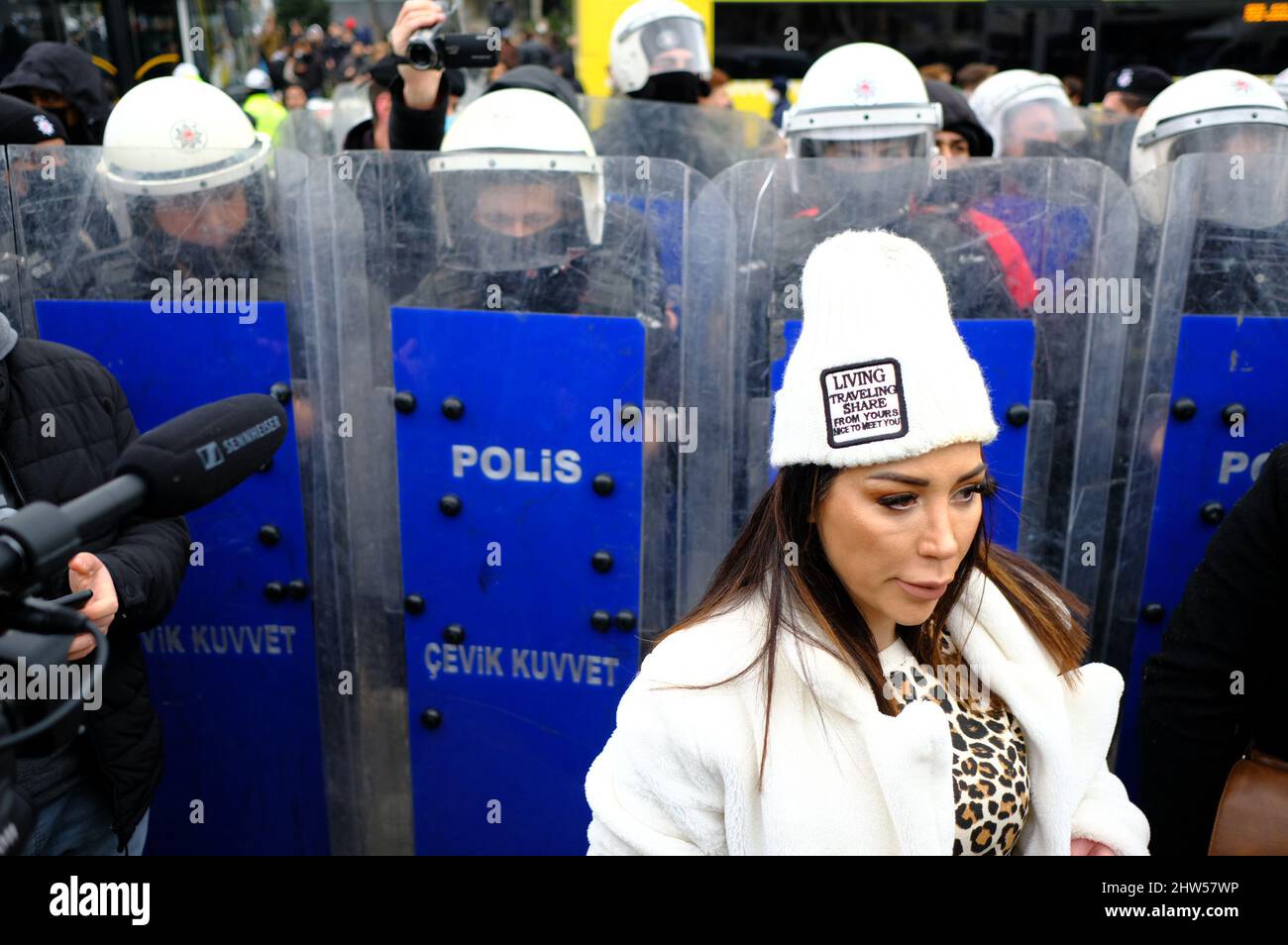 Riot police officers hold their shields in front of a demonstrator ...