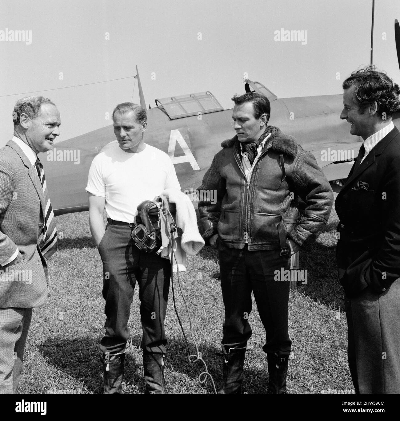 Famous Battle of Britain pilots visited the RAF station at Duxford, near Cambridge, today where the 'Battle of Britain' film is being made. The station is supposedly an RAF station in France, just prior to Dunkirk. Douglas Bader (left) talks to the stars of the film Robert Shaw and Christopher Plummer while Peter Townsend listens in. A Spitfire is in the background. 28th May 1968. Stock Photo