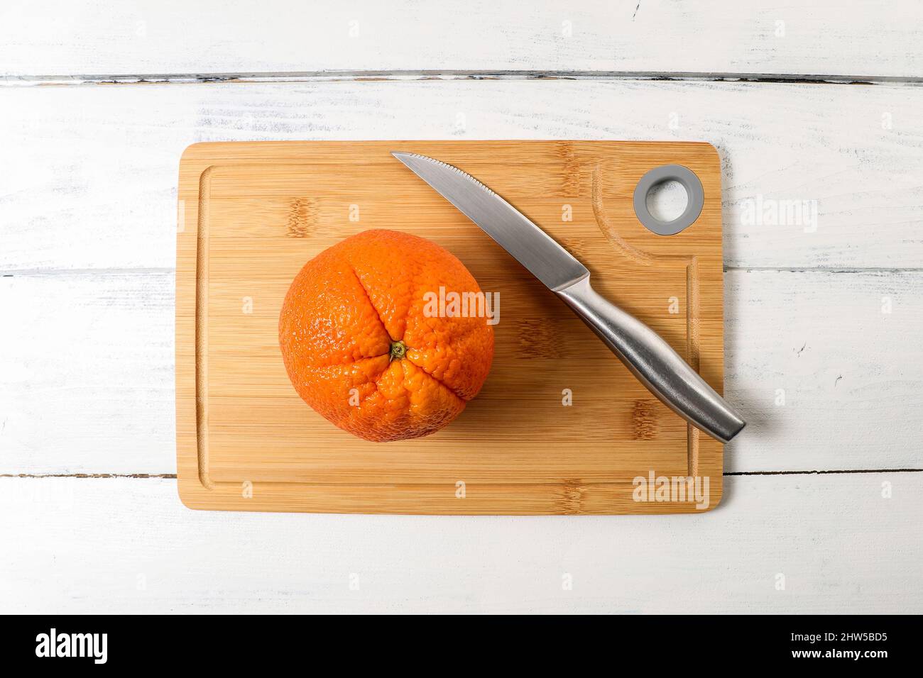 Big orange with a knife on a bamboo cutting board Stock Photo Alamy