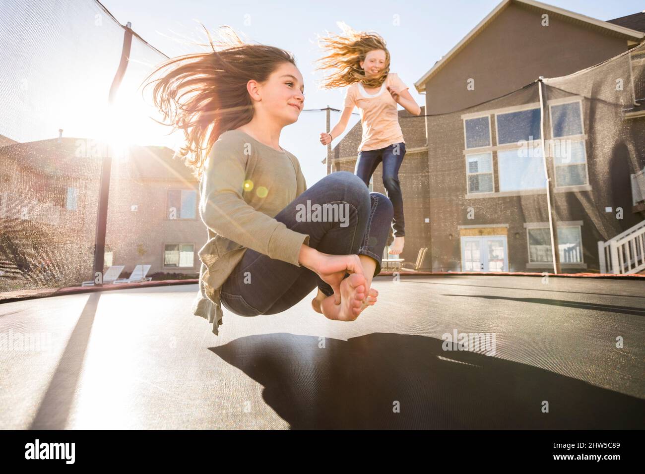 Two girls jumping on trampoline hi-res stock photography and images - Alamy