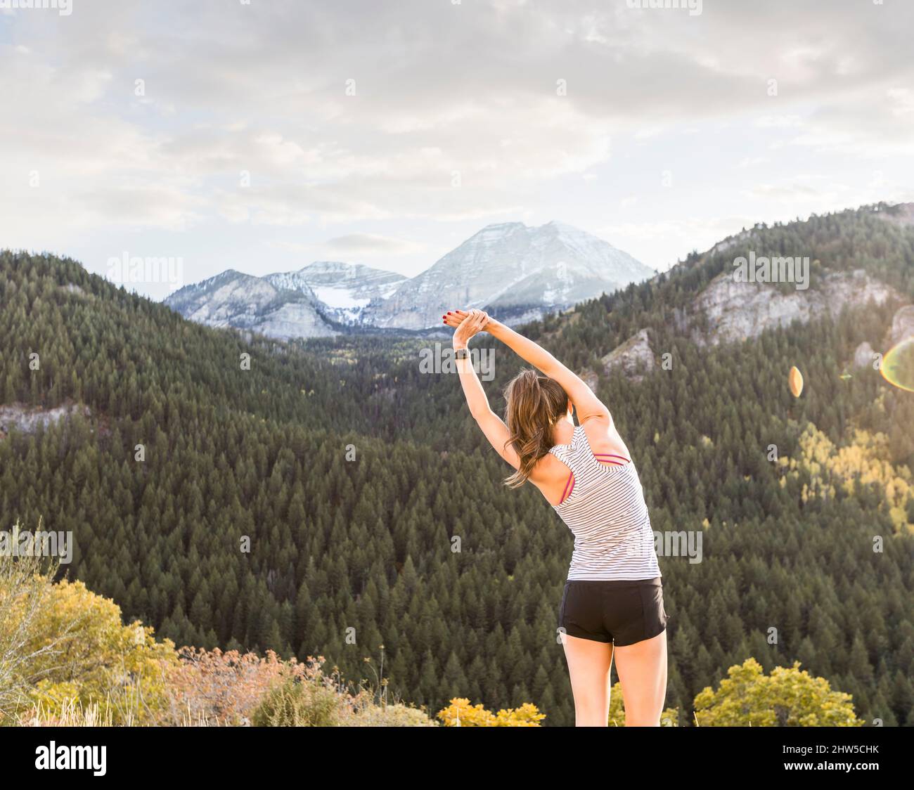United States, Utah, American Fork, Rear view of woman stretching in mountain landscape Stock Photo