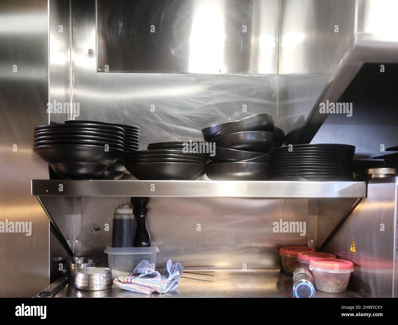 Restaurant with metal shelving with stacked dishes ready for kitchen service Stock Photo Alamy