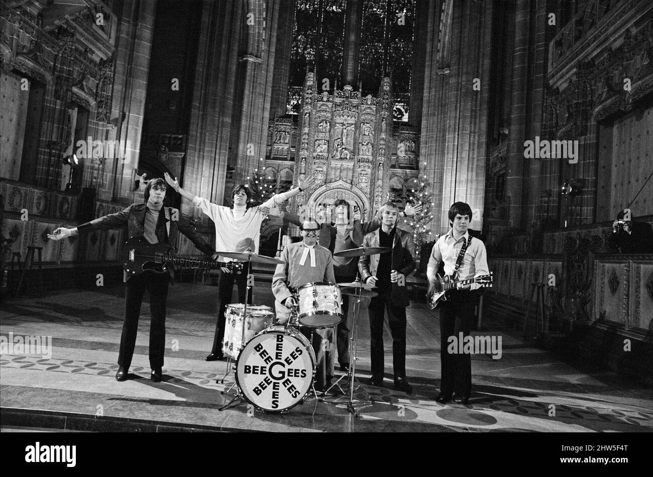 The Bee Gees perform at Liverpool Anglican Cathedral. The Bee Gees are brothers Maurice, Barry and Robin Gibb, Colin Peterson and Vince Malouney. The Dean of Liverpool, Rev. Edward Patey could not resist trying out the drums. 14th December 1967. Stock Photo