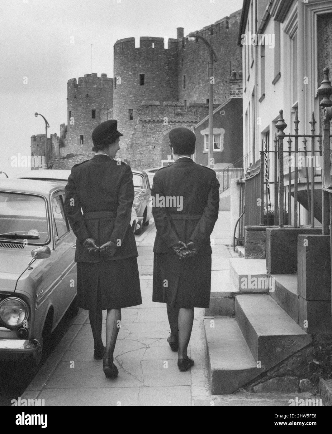 Women Police Officers, Pembrokeshire, West Wales, 18th April 1967.  June Roch (right) aged 31 from Bellevue Terrace, Pembroke Dock, and her friend and next door neighbour Ena Davies aged 35, are the only women special constables in South Pembrokeshire.   Pictured, on patrol with Pembroke Castle in background. Stock Photo
