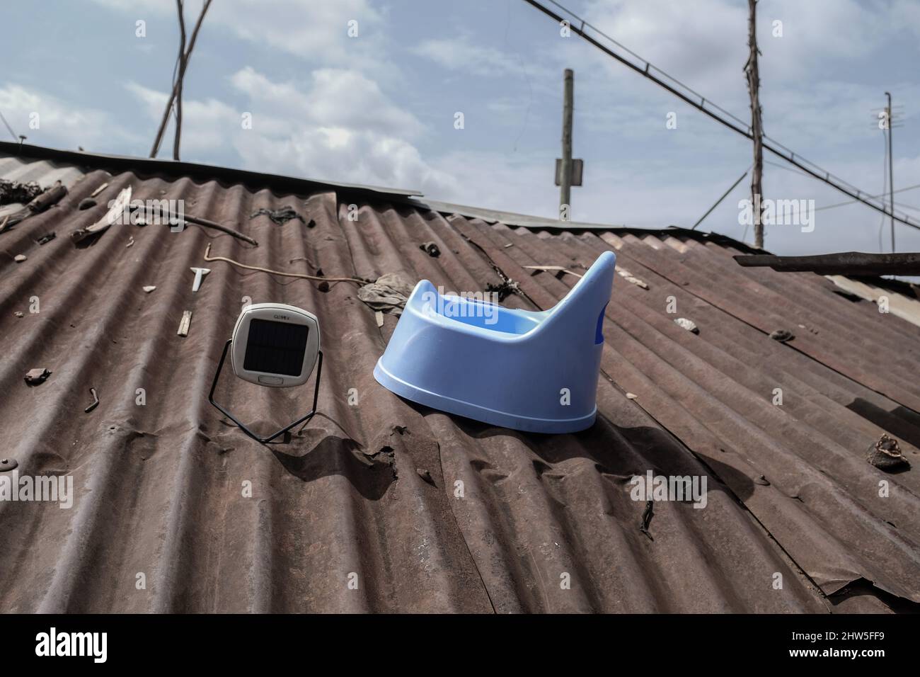A solar powered lamp charging on roof of a building structure in Kibera Slums, Nairobi. Thousand of households in Kenya's Kibera Slums depend on elect Stock Photo