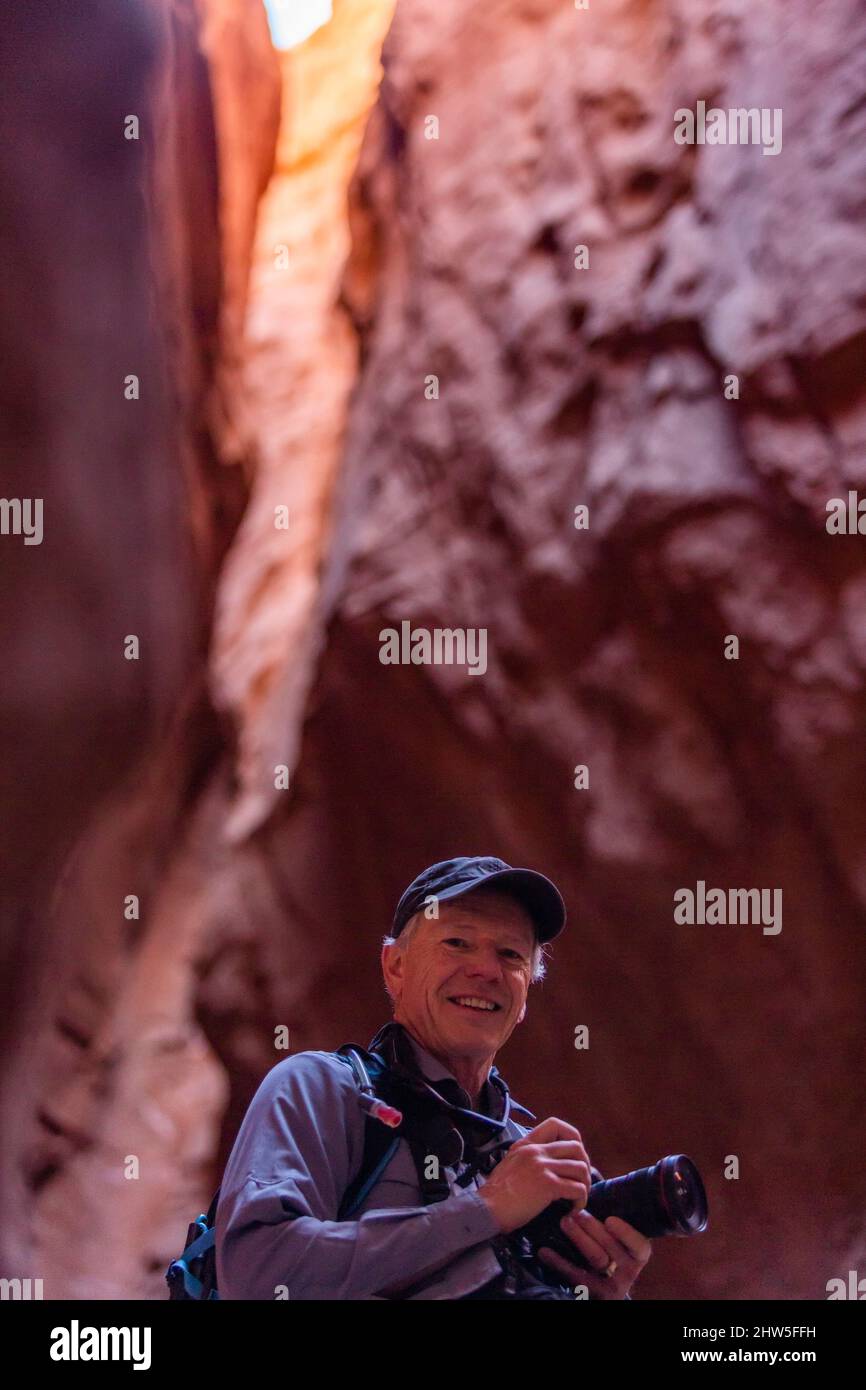 United States, Utah, Escalante, Senior male hiker with camera in canyon Stock Photo