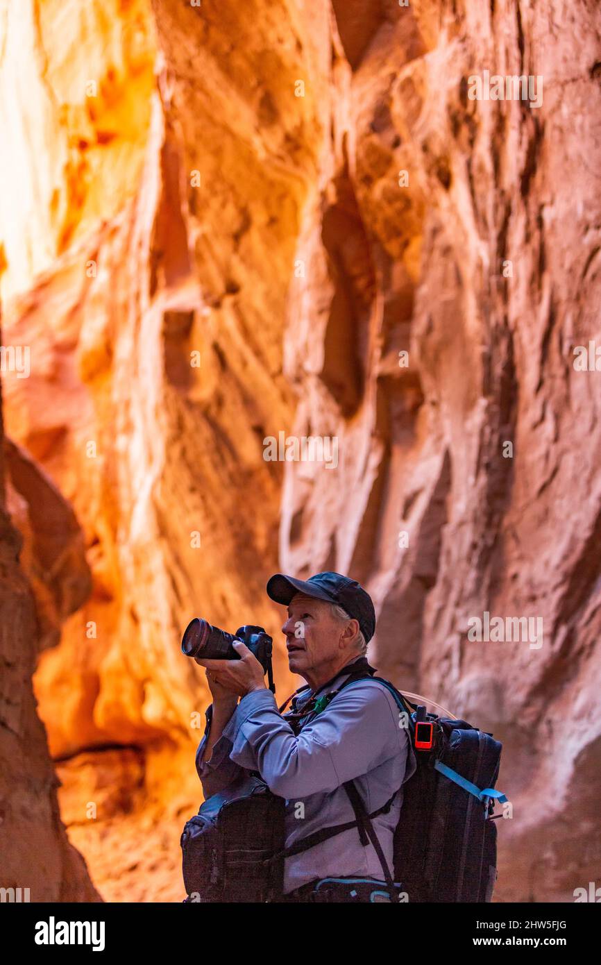 United States, Utah, Escalante, Senior hiker exploring and photographing rock formations in Kodachrome Basin State Park nearÂ EscalanteÂ Grand Staircase National Monument Stock Photo