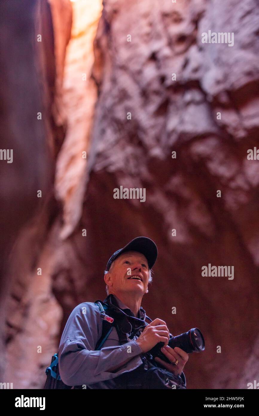 United States, Utah, Escalante, Senior male hiker with camera in canyon Stock Photo